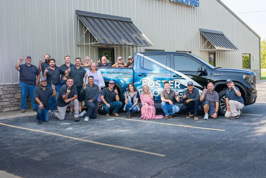 The Foster Roofing team gathered around a company truck at the Springdale office
